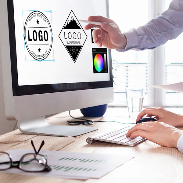 graphic design logos on apple monitor, woman pointing at screen